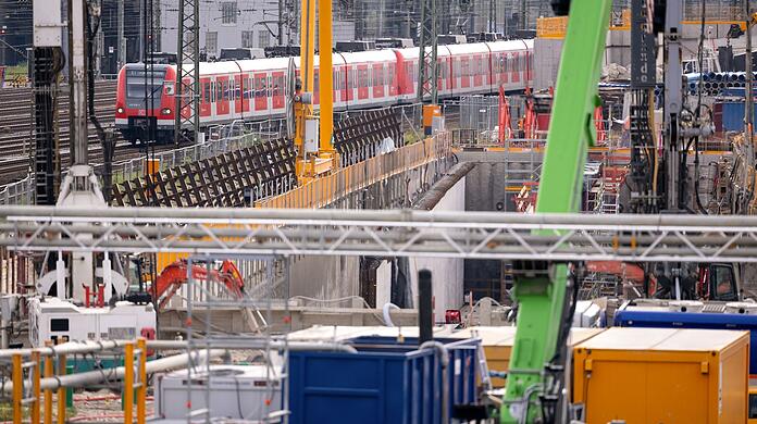 Ein Zug der S-Bahn München fährt an der Baustelle der zweiten S-Bahn-Stammstrecke entlang.