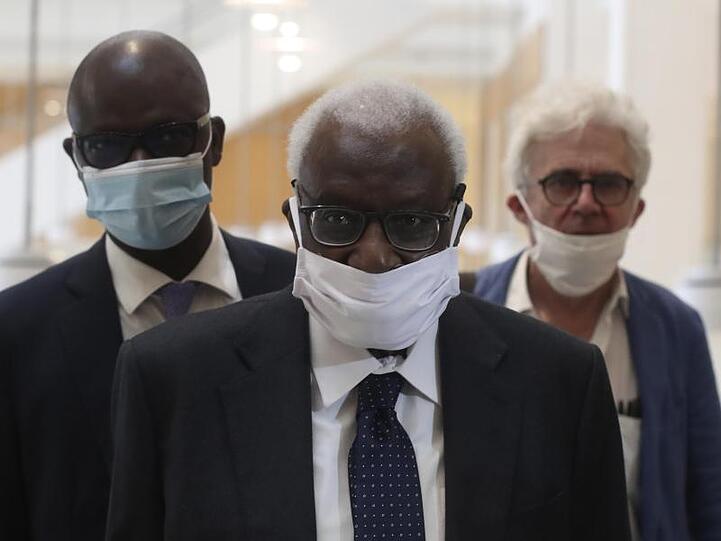 Den Corona-Regeln entsprechend mit einer Maske kommt Lamine Diack (M) mit seinem Anwalt William Bourdon (r) ins Pariser Gericht.