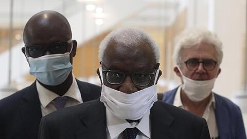 Den Corona-Regeln entsprechend mit einer Maske kommt Lamine Diack (M) mit seinem Anwalt William Bourdon (r) ins Pariser Gericht.