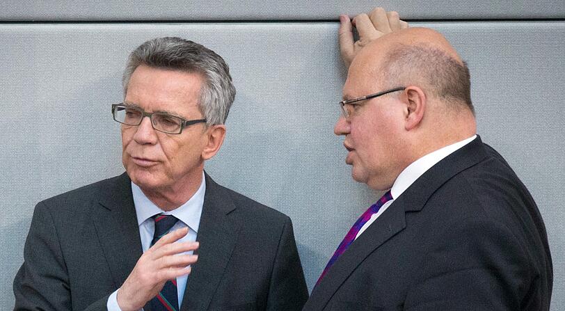 Der seinerzeitige Bundesinnenminister Thomas de Maiziere (CDU, l) und der damalige Kanzleramtsminister Peter Altmaier (r, CDU) unterhalten sich am Rande der Abstimmung über die geplante Asylgesetzreform im Deutschen Bundestag.