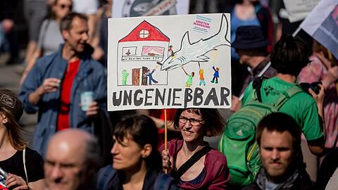#Mietenwahnsinn mit dem Transparent "Ungenießbar" und einem gezeichneten Miethai.