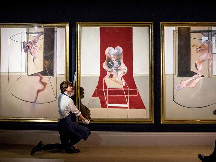Die drei Bilder des "Triptych inspired by the Oresteia of Aeschylus" werden von Mitarbeitern des Auktionshauses Sotheby's an der Wand ausgerichtet.