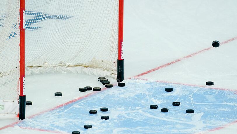 Eishockey-Pucks liegen im Torraum.
