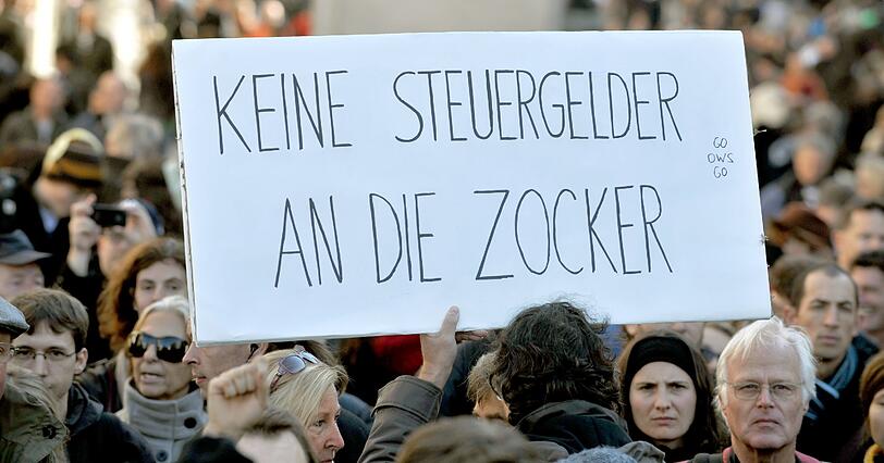 Demonstranten stehen mit Plakaten am Stachus in München (Vorbild der Demonstrationen ist die amerikanische Protestbewegung «Occupy Wall Street» («Besetzt die Wall Street»), die sich gegen das Finanzsystem und große Teile der Bankenwelt wendet.