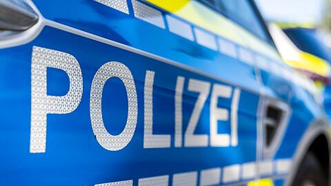 An der Tür von einem Streifenwagen steht der Schriftzug "Polizei".