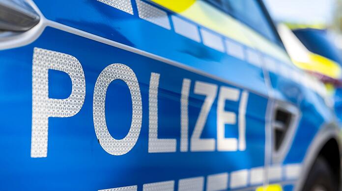 An der Tür von einem Streifenwagen steht der Schriftzug "Polizei".