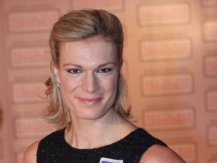 Maria Höfl-Riesch trägt den Pokal ins Olympiastadion.