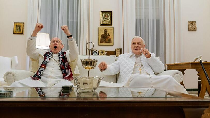 Beim gemeinsamen Schauen des WM-Finale 2014 Deutschland gegen Argentinien:
Jonathan Pryce als Franziskus und Anthony Hopkins als Ratzinger.