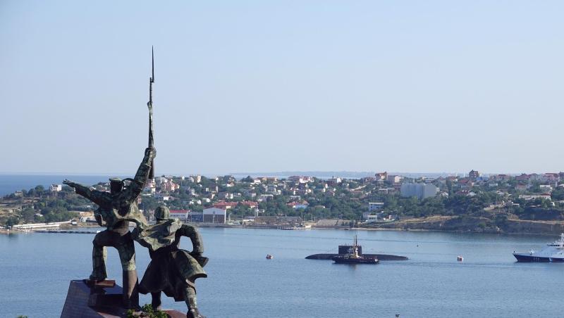 Hinter einem sowjetischen Denkmal liegen ein U-Boot und Kriegsschiffe der russischen Schwarzmeerflotte vor Anker in der Hafenstadt Sewastopol. (Archivbild).