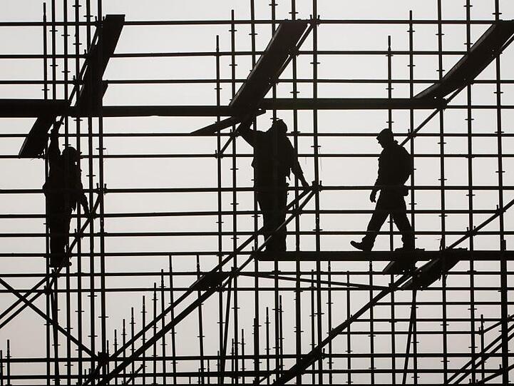 Gerüstbauer errichten in Hamburg auf einer Brückenbaustelle in der Hafencity ein Gerüst.