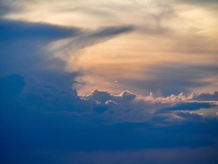 Eine Gewitterwolke, auch Gewitterzelle genannt, ist am Himmel im Sonnenuntergang zu sehen. Foto: Patrick Pleul/Archivbild