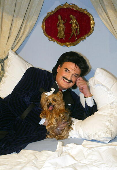 Rudolph Moshammer liegt mit seinem Hund Daisy im Bett.