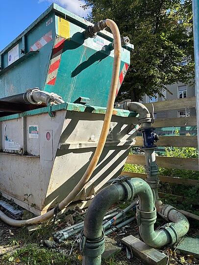 Das Loch-Wasser fließt durch einen mit Sand gefüllten Container.