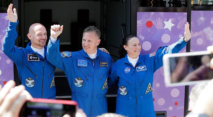 Der deutsche Astronaut Alexander Gerst (l-r), der russische Kosmonaut Sergej Prokopjew und die US-amerikanische Astronautin Serena Aunon-Chancellor winken vor ihrer Abfahrt mit einem Bus vom Hotel zum Kosmodrom.