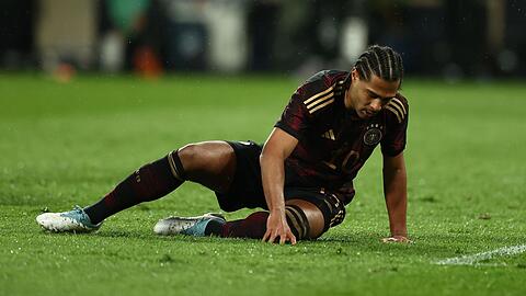 Deutschlands Serge Gnabry sitzt auf dem Rasen.