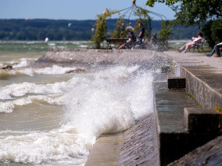 Ausflügler sitzen am Ufer des Ammersees. Foto: Sven Hoppe/dpa