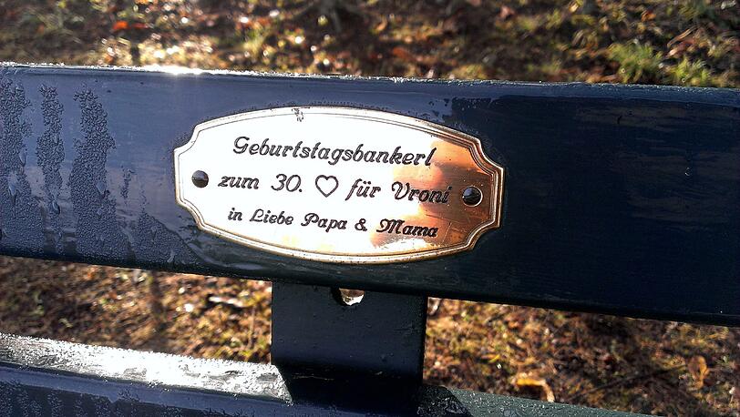 Im Englischen Garten und Nymphenburger Schlosspark haben Münchner tausende Plaketten mit Widmungen auf Parkbänken angebracht.