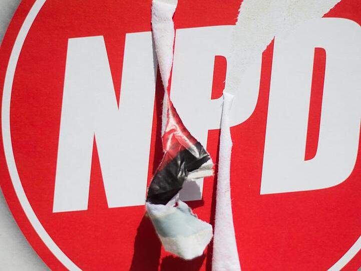 Ein zerstörtes Wahlplakat der Nationaldemokratischen Partei Deutschlands (NPD).