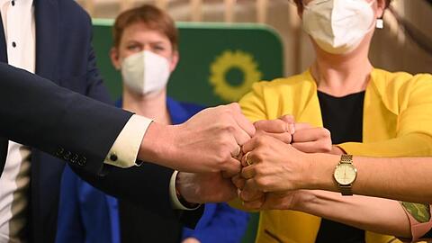 Mitglieder und Anhänger von Bündnis 90/Die Grünen bringen ihre Fäuste zusammen nach der Bekanntgabe der ersten Prognose zum Ergebnis der Landtagswahlen in Baden-Württemberg.