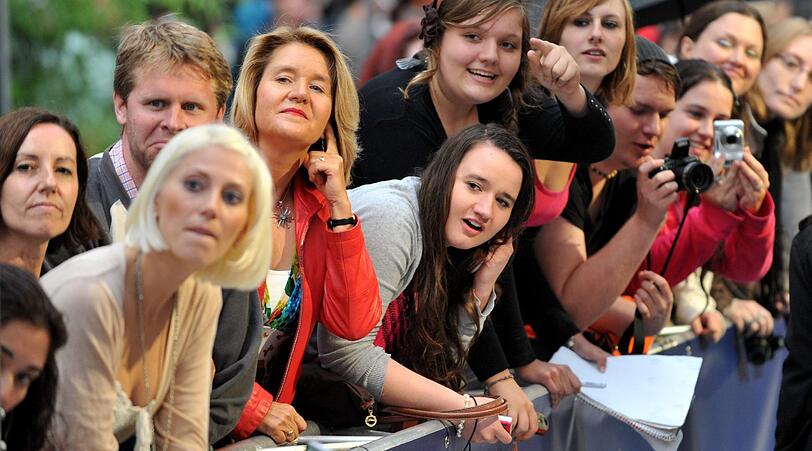 Weltstar im Fan-Gewusel: Robbie Williams verteilte Autogramme vor dem Mathäser-Kino.