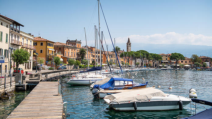 Boote liegen im Hafen des kleinen Ortes Maderno: Im Fall zweier Toter auf dem Gardasee nach einer mutmaßlichen Bootskollision hatte die italienische Polizei gegen zwei Deutsche ermittelt - in München läuft der Prozess.