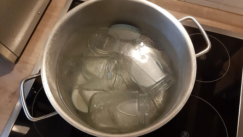 Marmeladengläser muss man vor dem Abfüllen unbedingt sterilisieren. Am besten kocht man sie samt Deckel für zehn Minuten ab.