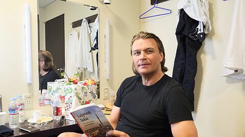 Klaus Florian Vogt mit Tokio-Führer in der Garderobe vor dem &bdquo;Tannhäuser&ldquo;.