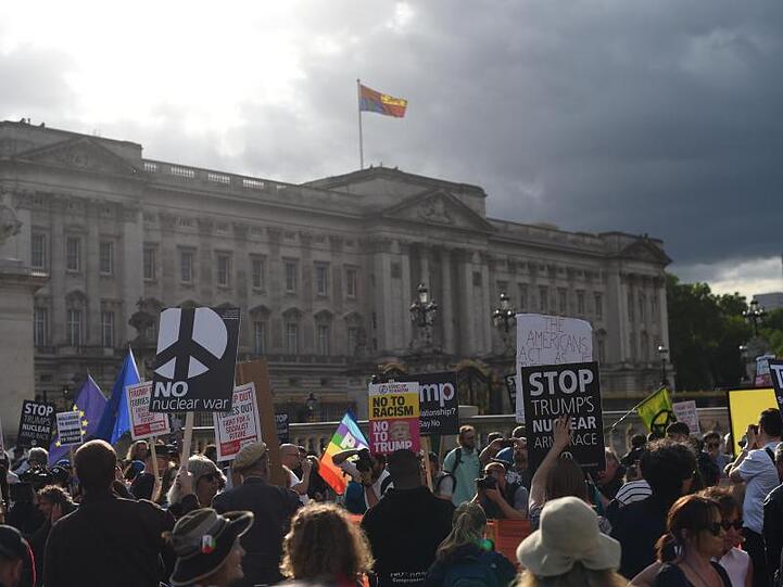 Gegner von US-Präsident Trump protestieren mit Schildern vor dem Buckingham Palast.