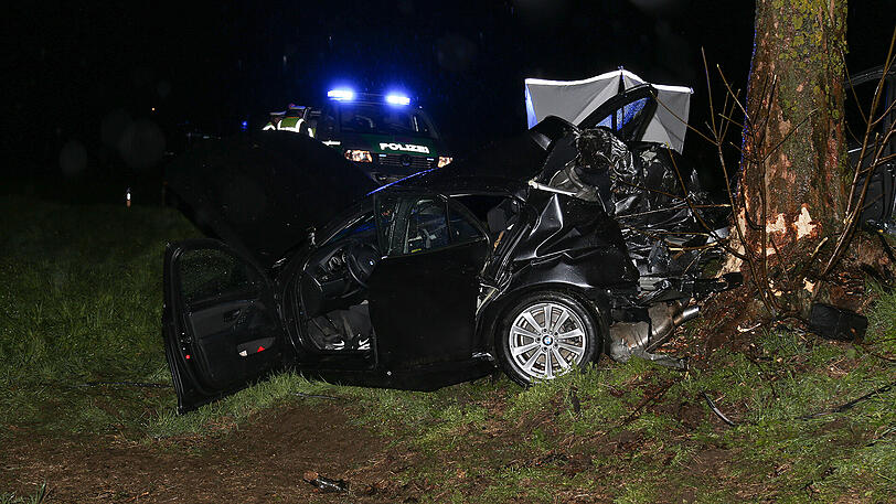 Schreckliche Bilder aus Icking: Der BMW kam von der Straße ab und prallte gegen einen Baum. Zwei 19-jährige Männer starben.