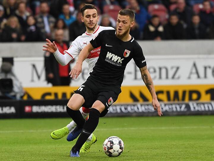 Stuttgarts Anastasios Donis und Augsburgs Jeffrey Gouweleeuw (l-r.) kämpfen um den Ball. Foto: Marijan Murat