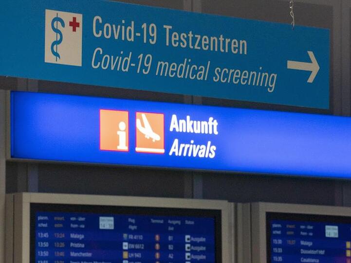 Ein Schild weist am Frankfurter Flughafen den Weg zum Covid-19-Testzentrum.