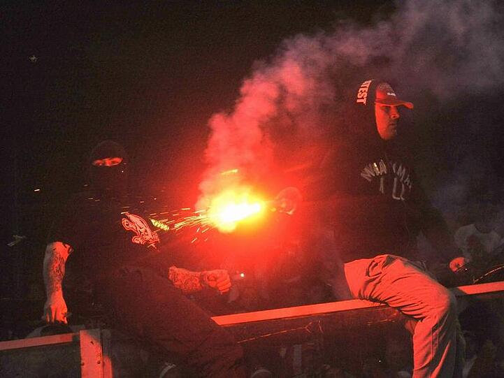 Serbische Hooligans zündeten bengalische Feuer und warfen sie auf den Rasen.