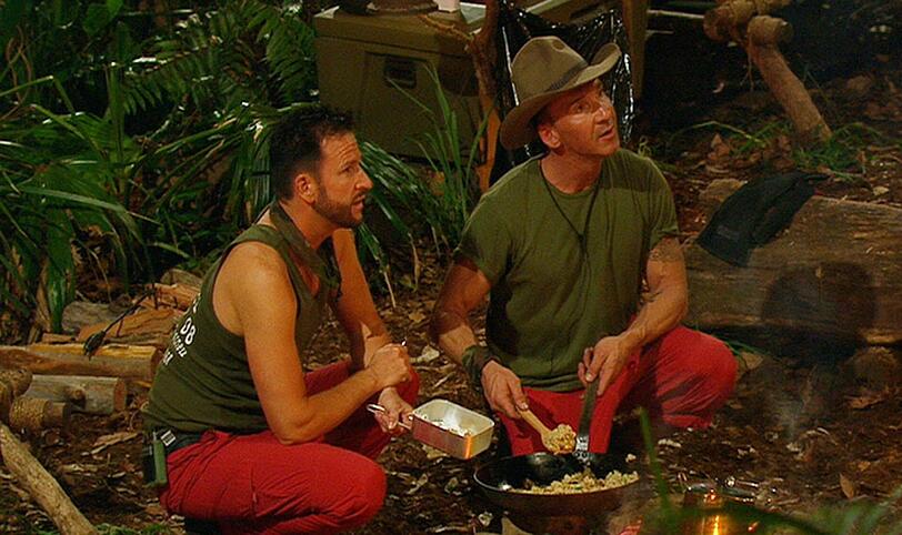 Michael Wendler (l.) und Jochen Bendel versuchen, etwas Schmackhaftes auf dem Lagerfeuer zu kochen. Bendel ist eigentlich ja ein Spitzenkoch.