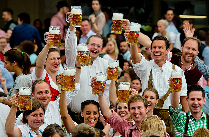 Die Krüge zum Himmel: Und dann geht es los für alle. Das Bier rinnt die durstigen Kehlen hinunter - die kommenden 16 Tage lang.