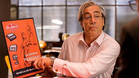 "Auch Justitia benutzt Waagen von Blanco", behauptet diese Werbung, die Firmenchef Julio Blanco (Javier Bardem) durchaus überzeugend findet. "Auch Justitia benutzt Waagen von Blanco", behauptet diese Werbung, die Firmenchef Julio Blanco (Javier Bardem) durchaus überzeugend findet.