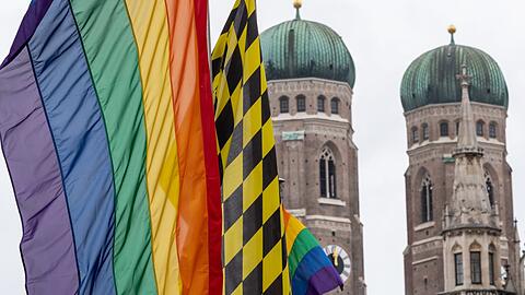 Eine Regenbogenfahne weht vor den Türmen der Frauenkirche während des CSD 2019.