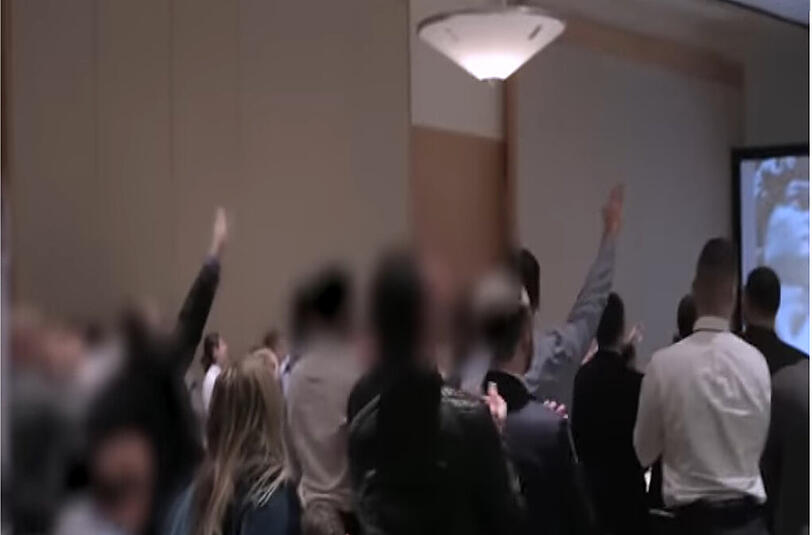 Ein Screenshot aus dem Video zeigt Besucher der Konferenz, die den Hitler-Gruß zeigen.