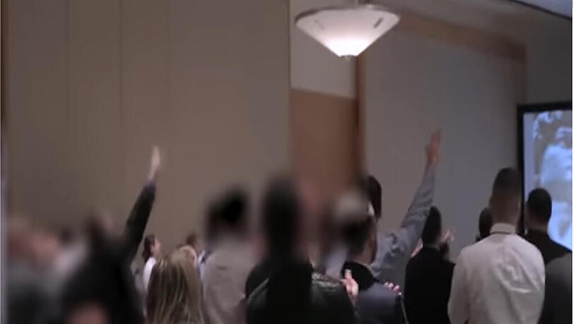 Ein Screenshot aus dem Video zeigt Besucher der Konferenz, die den Hitler-Gruß zeigen. Ein Screenshot aus dem Video zeigt Besucher der Konferenz, die den Hitler-Gruß zeigen.