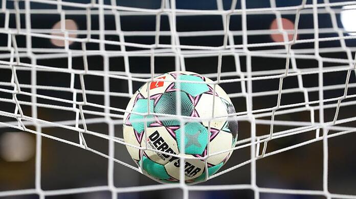 Ein Fußball liegt vor der Partie im Netz.
