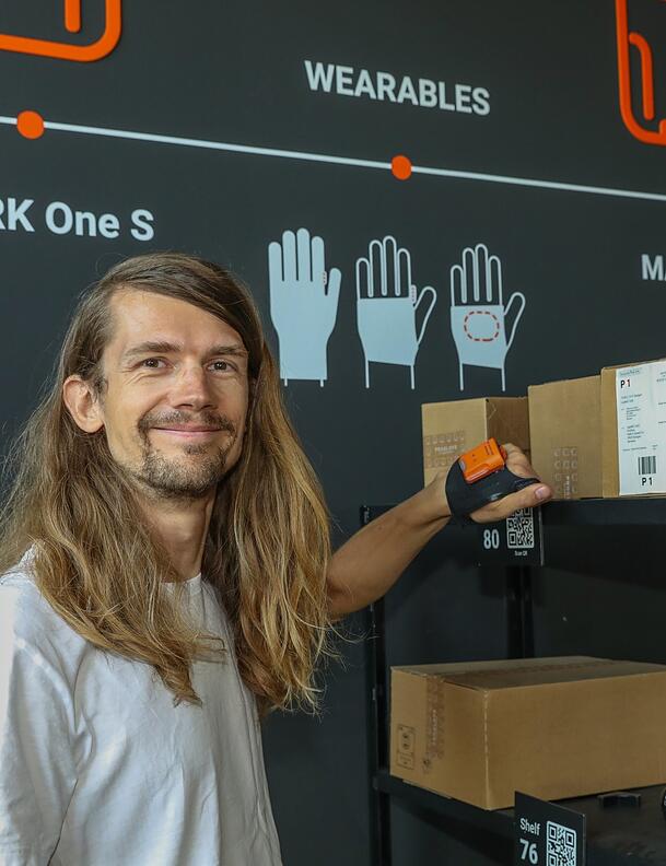 Günther (39) demonstriert einen Proglove-Handschuh. Der integrierte Barcode-Scanner wiegt nur etwa 40 Gramm. Günther (39) demonstriert einen Proglove-Handschuh. Der integrierte Barcode-Scanner wiegt nur etwa 40 Gramm.