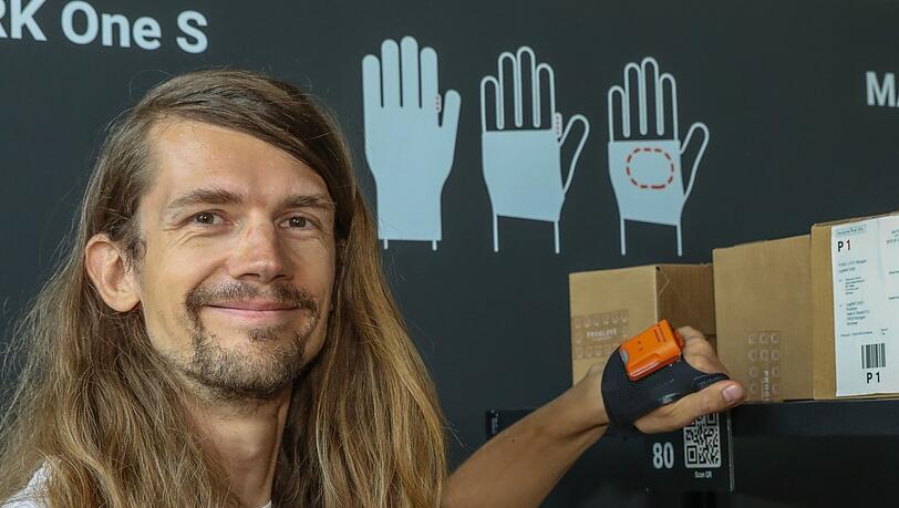 Günther (39) demonstriert einen Proglove-Handschuh. Der integrierte Barcode-Scanner wiegt nur etwa 40 Gramm. Günther (39) demonstriert einen Proglove-Handschuh. Der integrierte Barcode-Scanner wiegt nur etwa 40 Gramm.