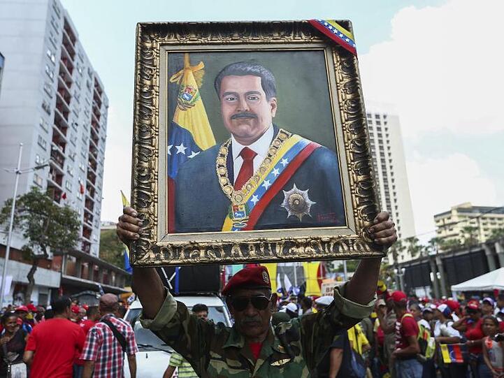 Ein Anhänger von Maduro mit einem Porträt des venezolanischen Präsidenten.