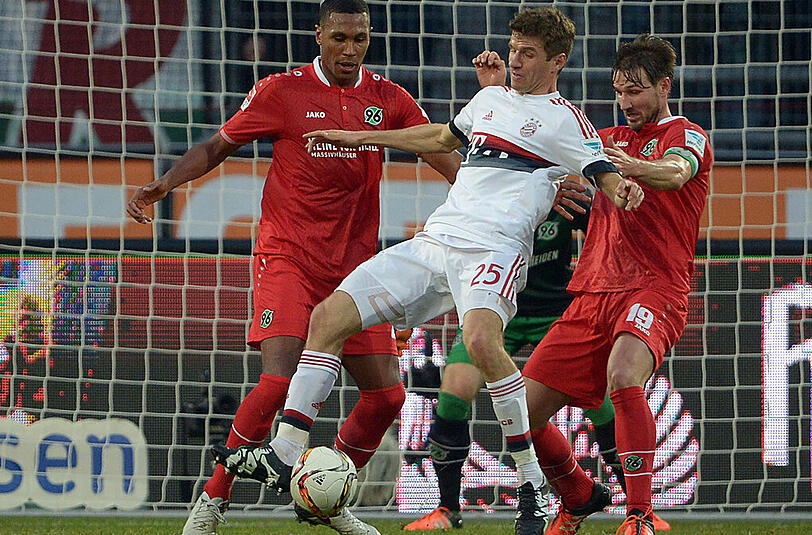 Szene aus dem Spiel Hannover 96 gegen Bayern München: Hannovers Marcelo (l) und Christian Schulz (r) kämpfen um den Ball gegen Münchens Thomas Müller.