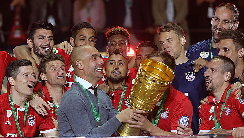 Kapitän Philipp Lahm (verdeckt) überlässt seinem scheidenden Coach Pep Guardiola (links) den Pokal zum ersten Jubler. Kapitän Philipp Lahm (verdeckt) überlässt seinem scheidenden Coach Pep Guardiola (links) den Pokal zum ersten Jubler.