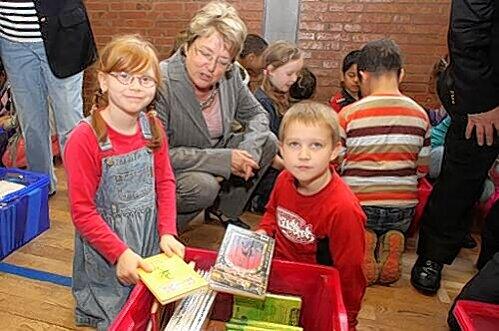 Schirmherrin Marga Beckstein lässt sich von Kamilla und Florian aus der Klasse 3d die neuen Bücher zeigen.