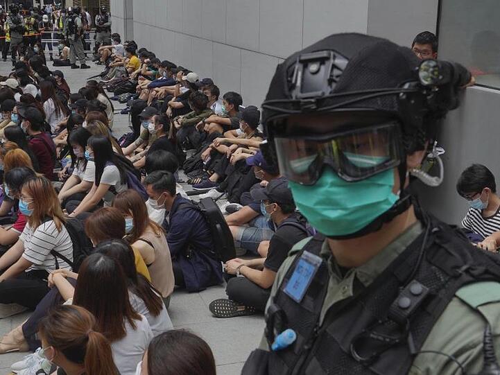Von Bereitschaftspolizisten festgehaltene regierungskritische Demonstranten im Zentrum von Hongkong.