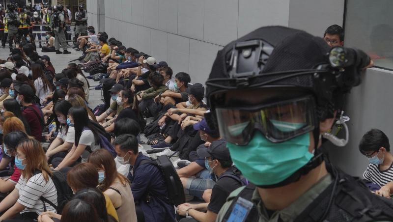 Von Bereitschaftspolizisten festgehaltene regierungskritische Demonstranten im Zentrum von Hongkong. Von Bereitschaftspolizisten festgehaltene regierungskritische Demonstranten im Zentrum von Hongkong.