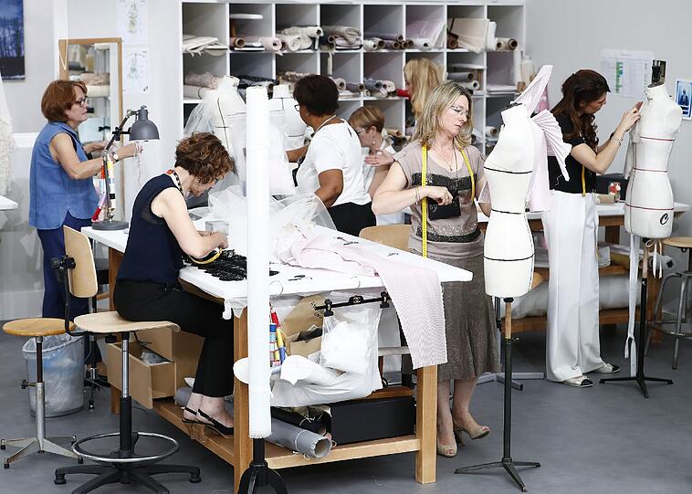 Die Models defilierten in einer Atelier-Szenerie mit Arbeitstischen, Schneiderpuppen und Bügeleisen.