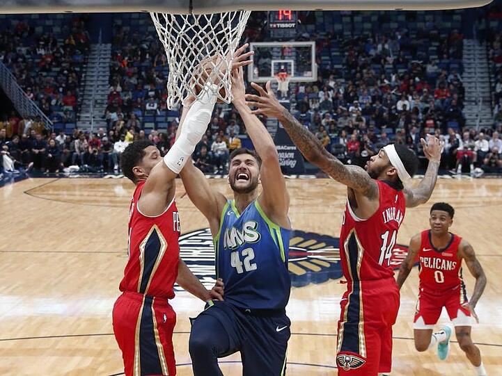 Der deutsche Mavericks-Profi Maxi Kleber (M.) setzt sich am Korb gleich gegen zwei Gegenspieler durch.