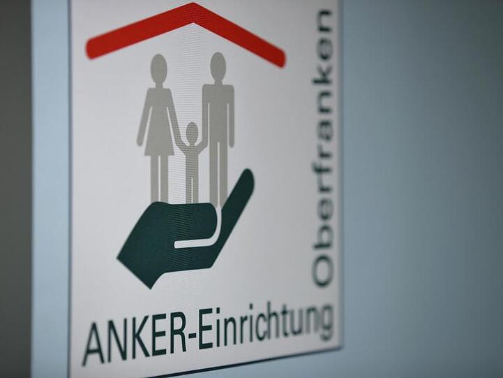 Anker-Einrichtung Oberfranken steht auf einem Banner in den Verwaltungsräumen des Ankerzentrums für Geflüchtete. Foto: Daniel Karmann/Archiv